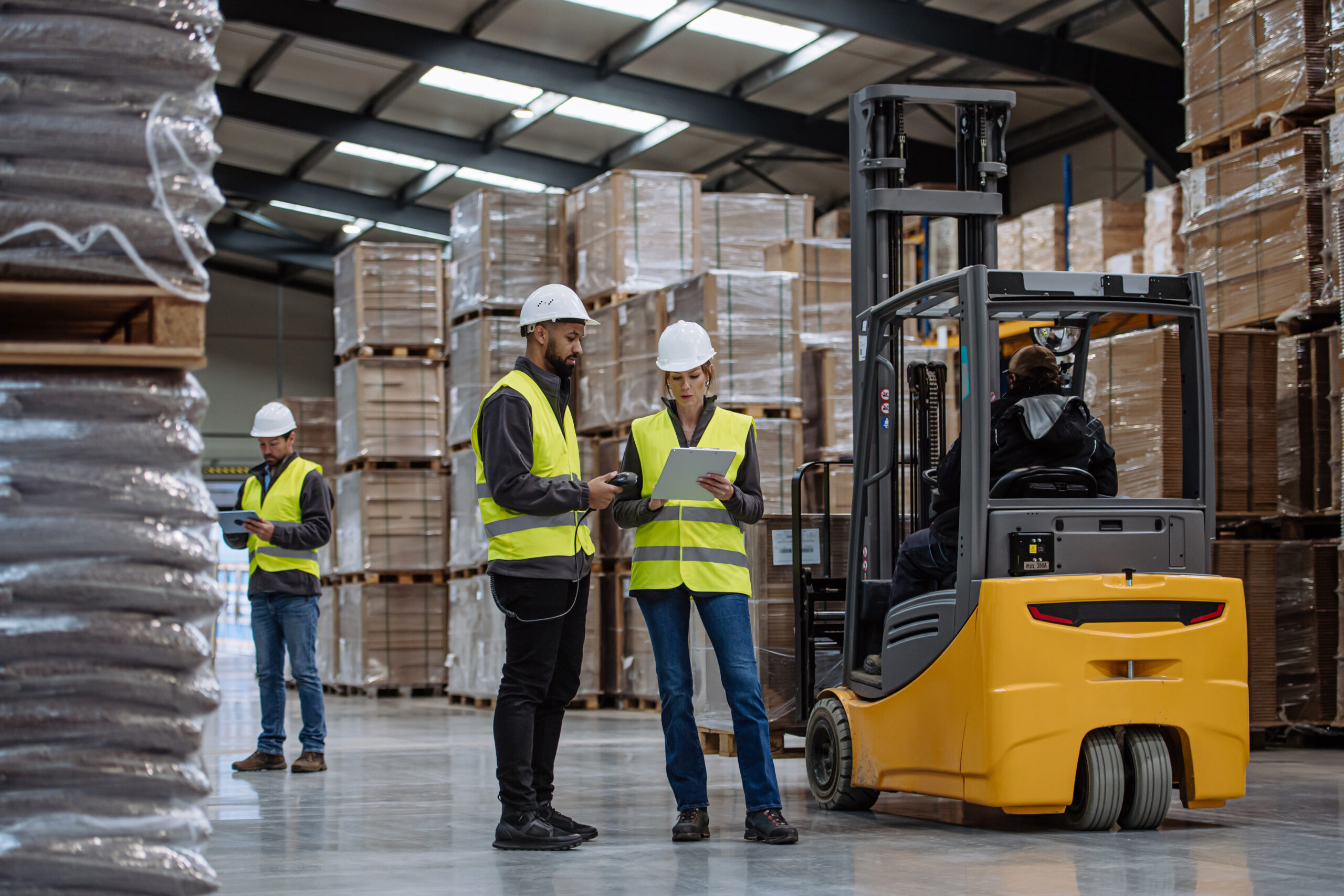 Warehouse workers reading product order, order picking. Warehouse manager checking delivery, stock in warehouse, inspecting products for shipment.
